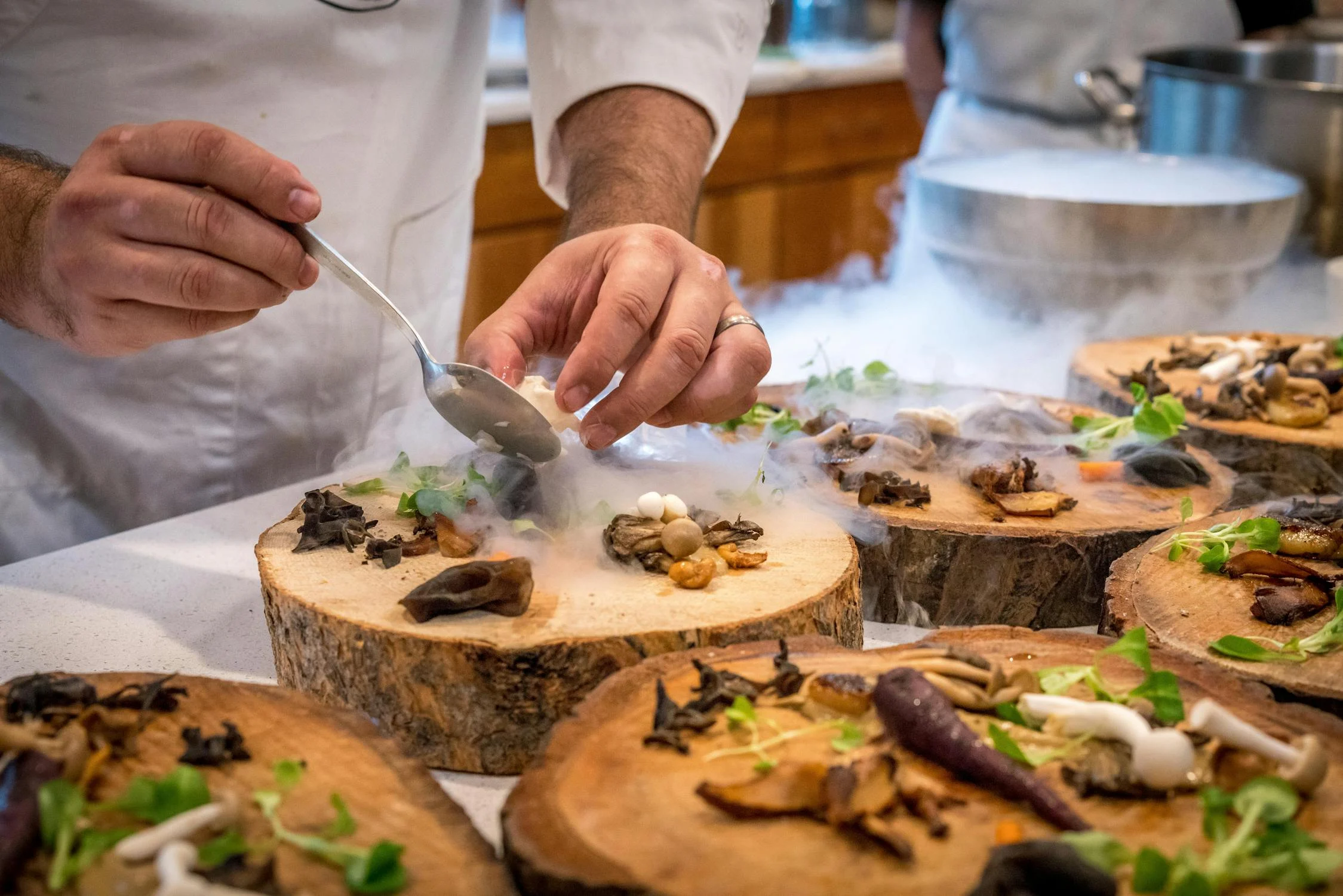 chefs preparing foods on tree slabs
